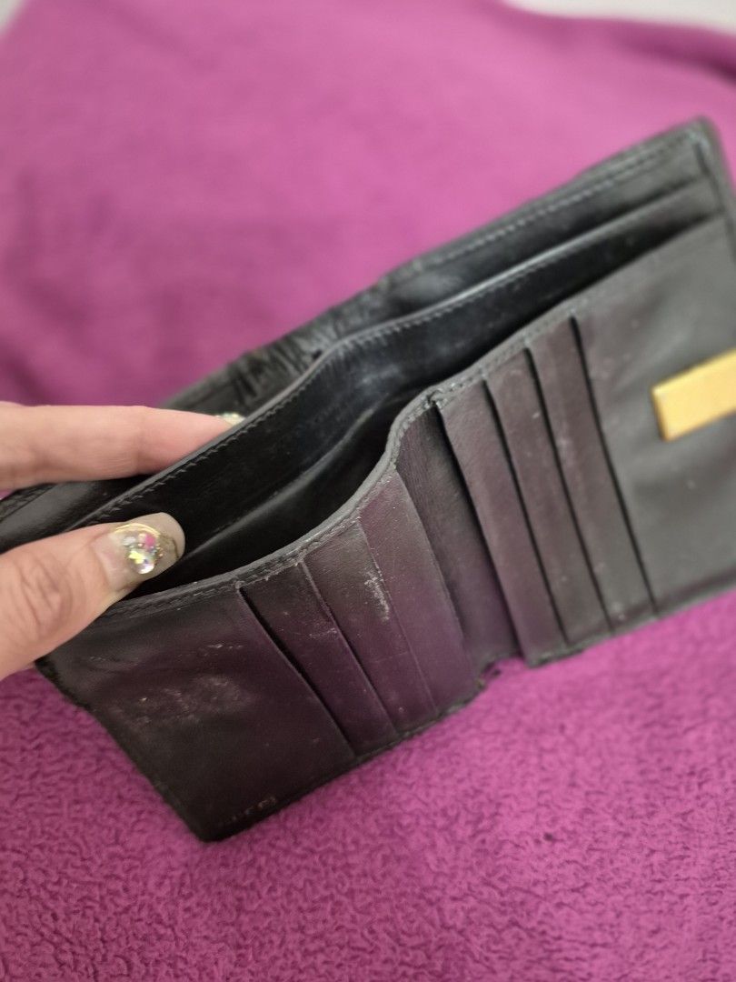 Gucci Black Leather Wallet (Category: Luxury Bags & Wallets) located in Angeles City. Submitted by clie15 (Listing ID 1396710614, Image 3). Description: - Authentic Gucci wallet - Black leather exterior - Gold-tone clasp with Gucci logo - Multiple card slots and compartments - Textured finish - Clasp features two dark spherical accents.