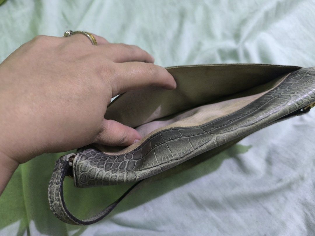 Kate Spade Grey Crocodile-Embossed Handbag (Category: Luxury Bags & Wallets) located in Quezon City. Submitted by mitchrebur80628 (Listing ID 1396691870, Image 1). Description: - Kate Spade handbag - Grey crocodile-embossed exterior - Top handle - Flap closure - Tan interior - Interior zipper pocket - Gold-toned zipper pull - Kate Spade label inside - Clutch or small shoulder bag.