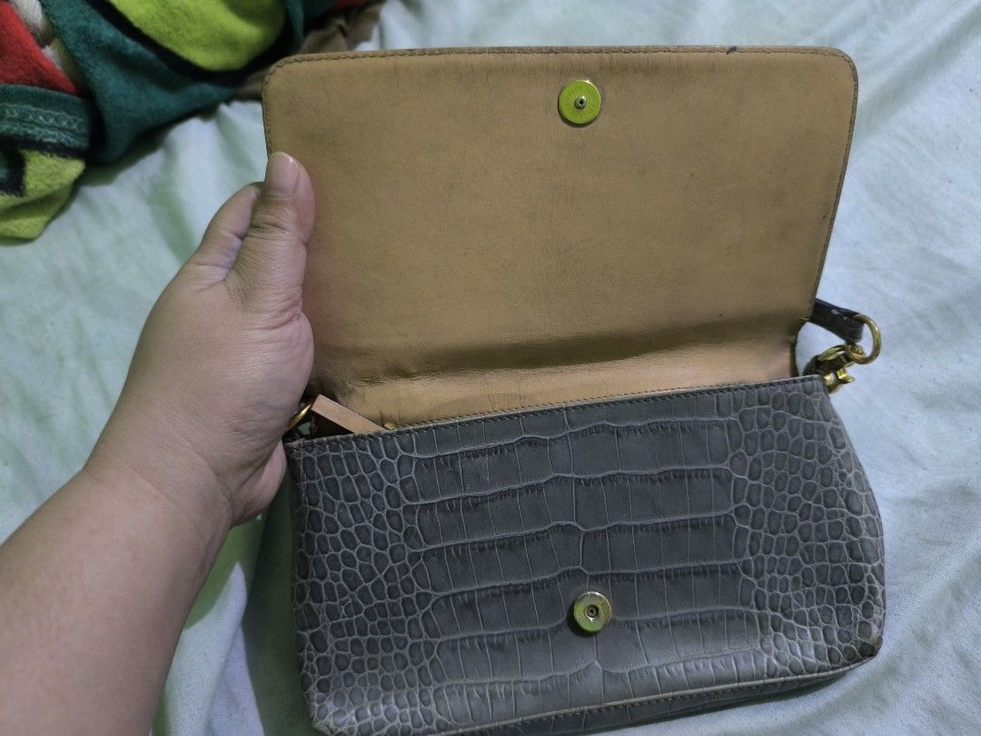 Kate Spade Grey Crocodile-Embossed Handbag (Category: Luxury Bags & Wallets) located in Quezon City. Submitted by mitchrebur80628 (Listing ID 1396691870, Image 2). Description: - Kate Spade handbag - Grey crocodile-embossed exterior - Top handle - Flap closure - Tan interior - Interior zipper pocket - Gold-toned zipper pull - Kate Spade label inside - Clutch or small shoulder bag.