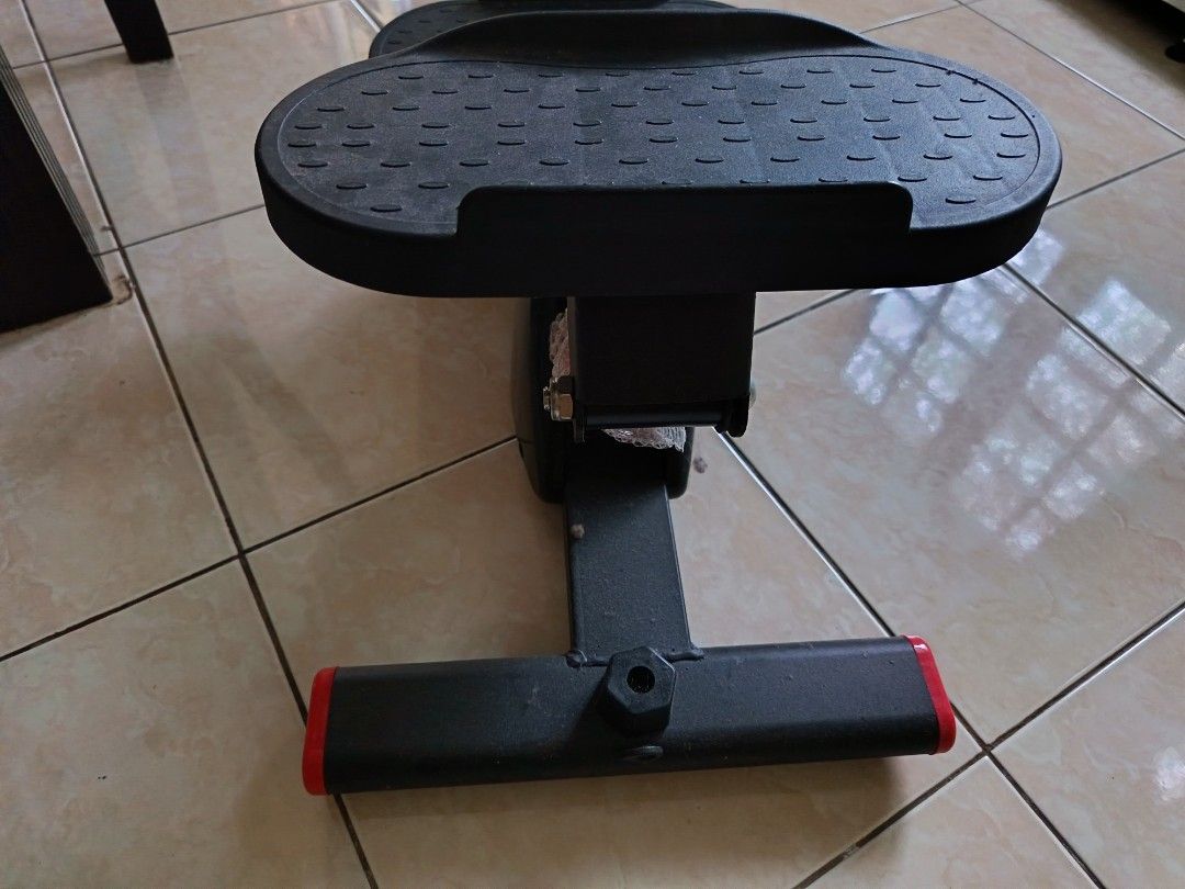 Mini Stepper Exercise Machine (Category: Cardio & Fitness Machines) located in Gombak. Submitted by kerolawar (Listing ID 1396760413, Image 2). Description: Compact mini stepper for home workouts. Features two foot pedals and a central support structure. The stepper has a black frame with red accents on the feet. Perfect for cardio and leg exercises in a small space..