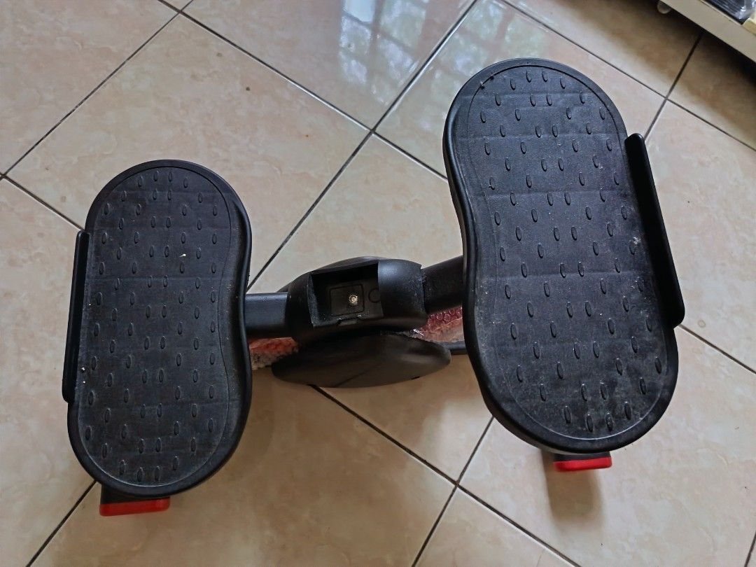 Mini Stepper Exercise Machine (Category: Cardio & Fitness Machines) located in Gombak. Submitted by kerolawar (Listing ID 1396760413, Image 3). Description: Compact mini stepper for home workouts. Features two foot pedals and a central support structure. The stepper has a black frame with red accents on the feet. Perfect for cardio and leg exercises in a small space..
