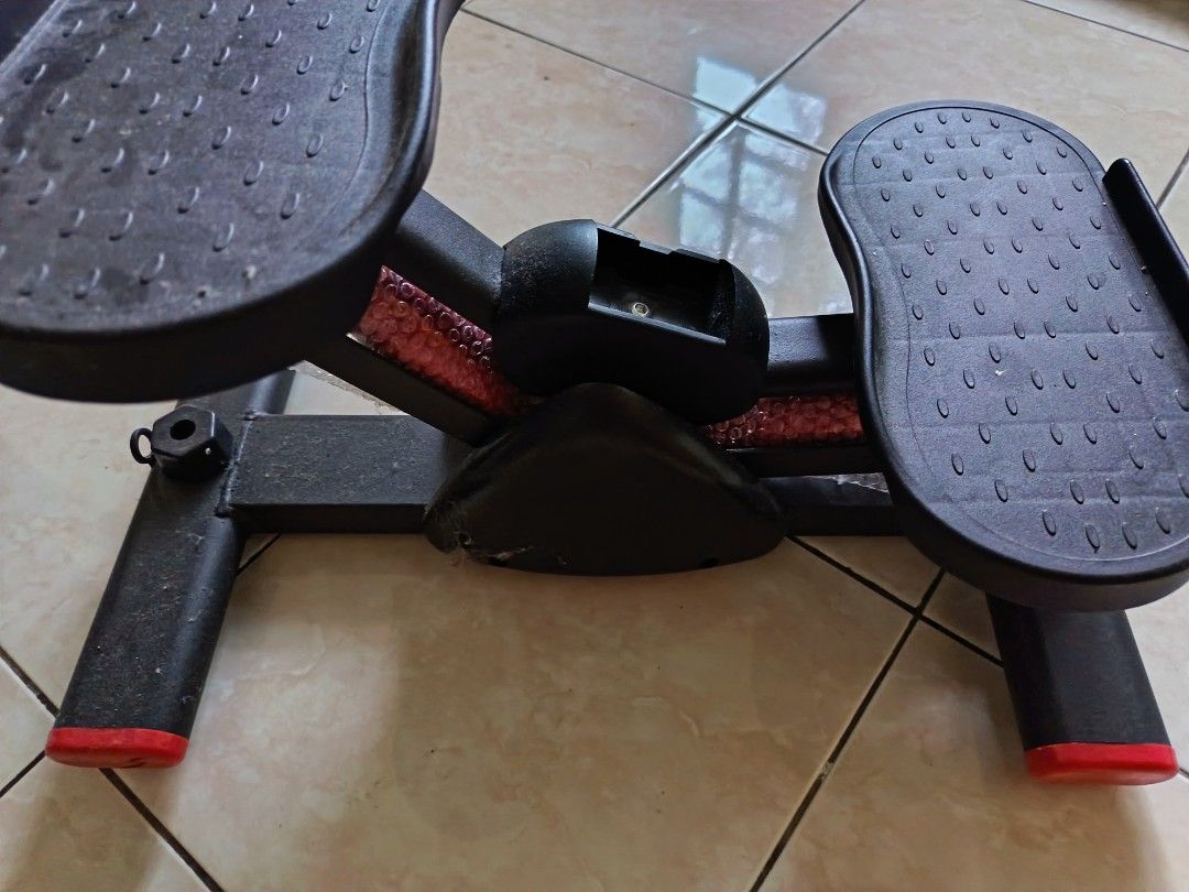 Mini Stepper Exercise Machine (Category: Cardio & Fitness Machines) located in Gombak. Submitted by kerolawar (Listing ID 1396760413, Image 1). Description: Compact mini stepper for home workouts. Features two foot pedals and a central support structure. The stepper has a black frame with red accents on the feet. Perfect for cardio and leg exercises in a small space..