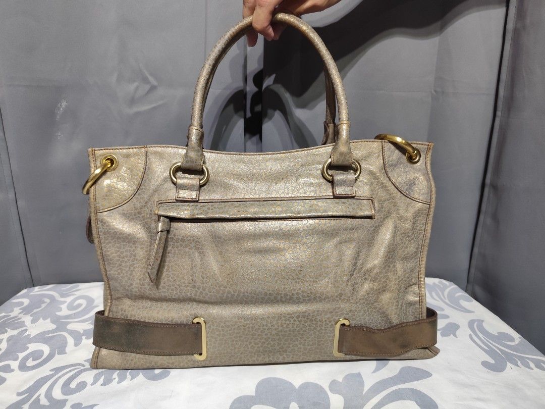 Renoma Paris Handbag (Category: Luxury Bags & Wallets) located in Santa Rosa. Submitted by ahroncatpad (Listing ID 1396826121, Image 2). Description: - Stylish Renoma Paris handbag - Textured exterior - Front flap pocket - Wide belt detail - Double handles - Zip closure - Interior zip pocket - Multiple compartments - Gold-tone hardware - Brown interior lining - Spacious interior.