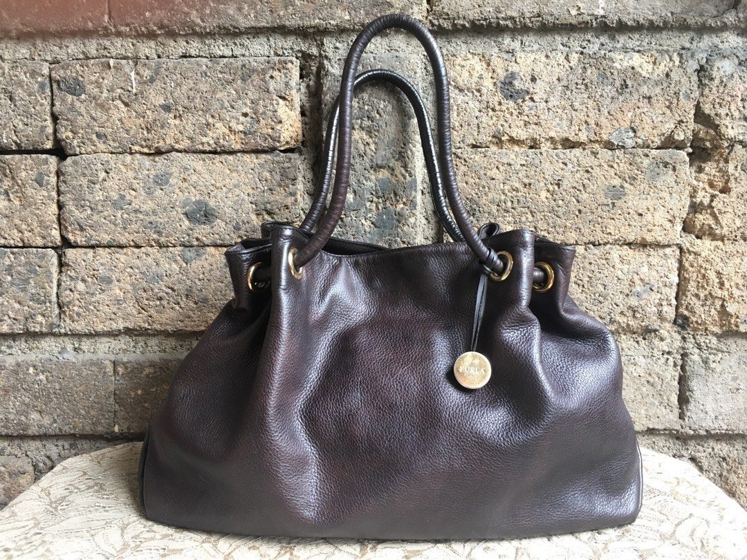 Authentic Furla Carmen Shoulder Bag (Category: Shoulder Bags) located in Marikina City. Submitted by arrveefm (Listing ID 1396851157, Image 2). Description: Authentic Furla Carmen Shoulder Bag Material: Genuine Leather Used but still in good condition (Check pictures for visible flaws; No Meet-ups; Payment thru BDO/GCash Color: Dark Brown Made in Tunisia Selling for Php 3,500.00 + Shipping Smooth leather, magnetic closure. Interior pockets - one 