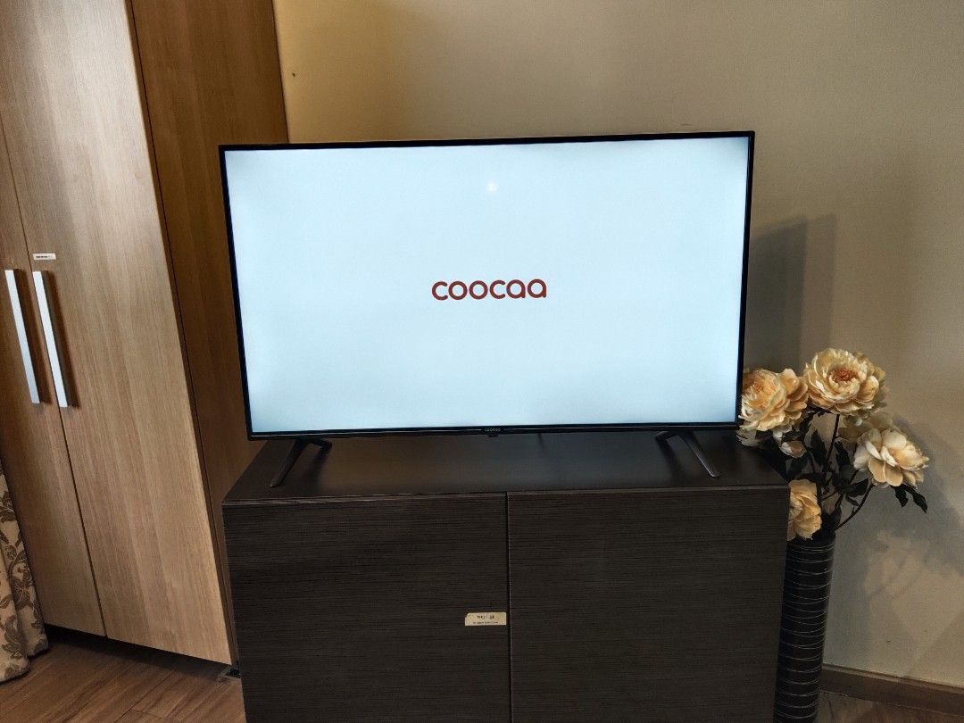 Coocaa Smart TV (Category: TV) located in Makati City. Submitted by theseasonstrend (Listing ID 1396879770, Image 1). Description: - Coocaa Smart TV with Google TV - Includes Netflix, YouTube, and Prime Video apps - Mounted on a dark brown cabinet - Displays Coocaa logo and Google TV home screen - In good working condition.