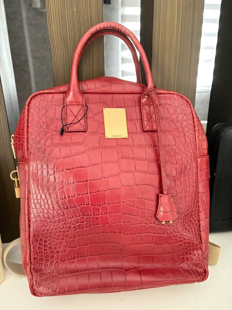 Couronne Red Croc-Embossed Backpack (Category: Luxury Bags & Wallets) located in Cavite. Submitted by misa_destash (Listing ID 1396866641, Image 1). Description: Couronne handbag features a red croc-embossed exterior with gold-tone hardware. It has a top handle and a detachable backpack straps. The interior includes a zippered pocket. The bag has a gold-tone lock with the Couronne logo. The bag has a rectangular shape with a zipper closure. Authe