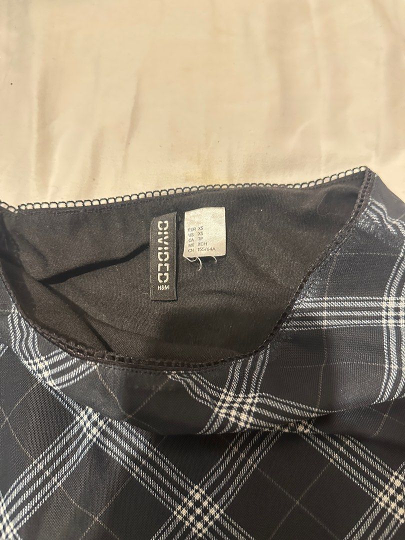 H&M Divided Plaid Mini Skirt (Category: Skirts) located in Manila. Submitted by cchaiprincess (Listing ID 1396978371, Image 2). Description: > cash first MOP: gcash rfs: not my style anymore - H&M Divided mini skirt - Classic plaid pattern - Black base with white and light blue grid lines - Wavy hemline - Black lining - Size: XS - Versatile for different outfits.