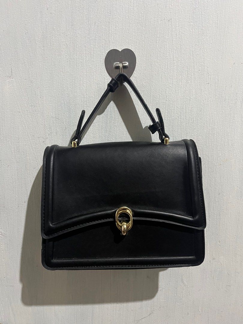 Jovanni Black Handbag (Category: Luxury Bags & Wallets) located in Manila. Submitted by yap11111 (Listing ID 1396970099, Image 1). Description: - Jovanni black handbag - Gold-tone clasp and zipper - Interior zippered pocket - Structured design - Top handle - Made of leather or leather-like material.