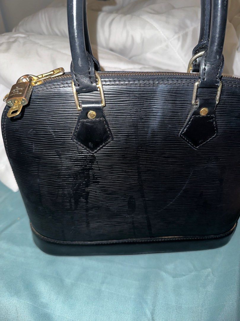 Louis Vuitton Alma Epi Leather Handbag (Category: Luxury Bags & Wallets) located in Quezon City. Submitted by lindthings (Listing ID 1396984314, Image 1). Description: - Authentic Louis Vuitton Alma handbag - Color: Black - Structured silhouette - Top zip closure - Rolled leather handles - Includes padlock and key.