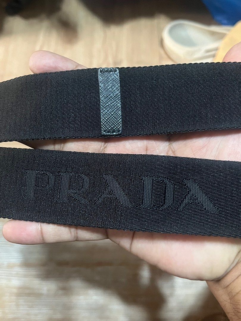 Prada Black Bag Strap (Category: Luxury Bags & Wallets) located in Carmen. Submitted by by_your_stuff (Listing ID 1396868433, Image 3). Description: - Prada bag strap - Black color - Gold-tone hardware - Prada logo embossed - Durable, woven material - Leather details on ends - Includes two gold clasps for easy attachment.