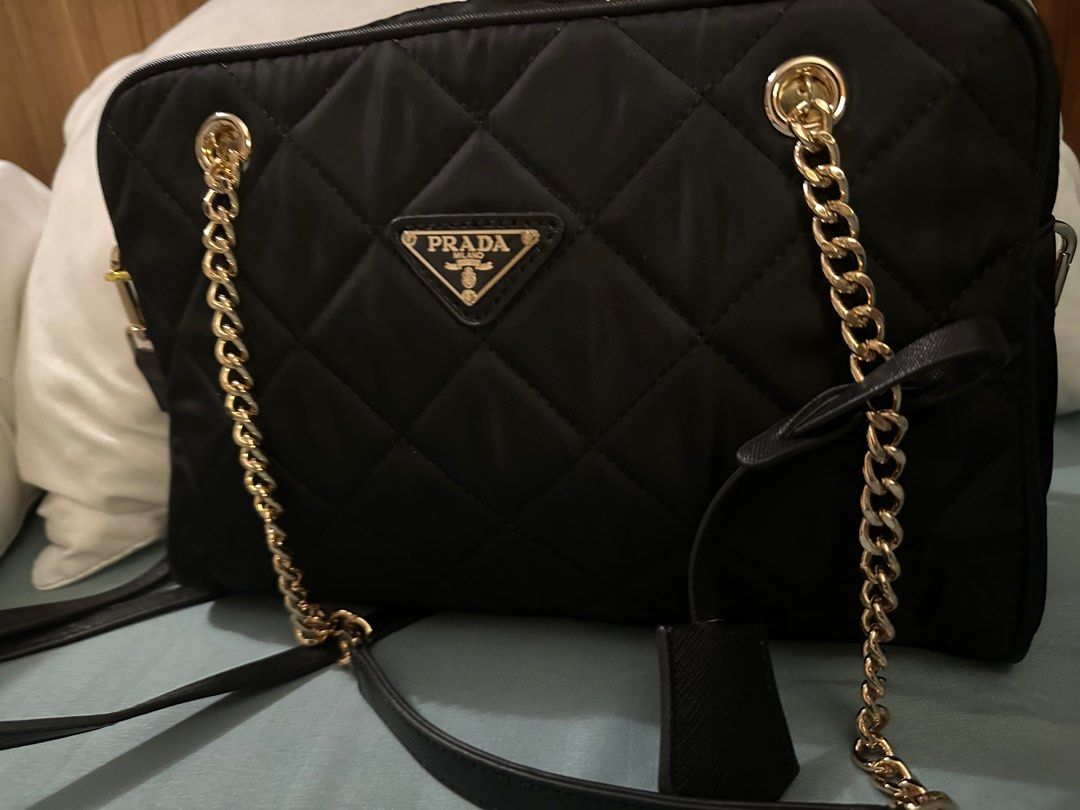 Prada Quilted Shoulder Bag with Chain Strap (Category: Luxury Bags & Wallets) located in Quezon City. Submitted by lindthings (Listing ID 1396979942, Image 1). Description: - Prada black quilted shoulder bag - Gold-tone chain strap - Prada logo detail - Includes a detachable tag - Made of nylon - Features both a top handle and shoulder strap.