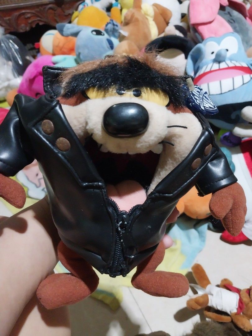 Tazmanian Devil Plush Toy (Category: Plushies & Soft Toys) located in Abucay. Submitted by g_treasures (Listing ID 1396878193, Image 1). Description: - Tazmanian Devil plush toy - Features a black jacket - Brown fur and limbs - Includes a zipper closure - Jacket has a patch - Collectible item - Great for Looney Tunes enthusiasts.