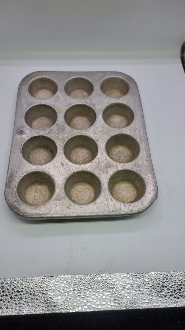 12-Cup Muffin Pan small (Category: Bakeware) located in Marikina City. Submitted by andreah_16 (Listing ID 1397213516, Image 1). Description: - 12-cup muffin pan - Made of metal - Rectangular shape with rounded corners - All cups are intact - Ideal for muffins, cupcakes, and mini quiches.