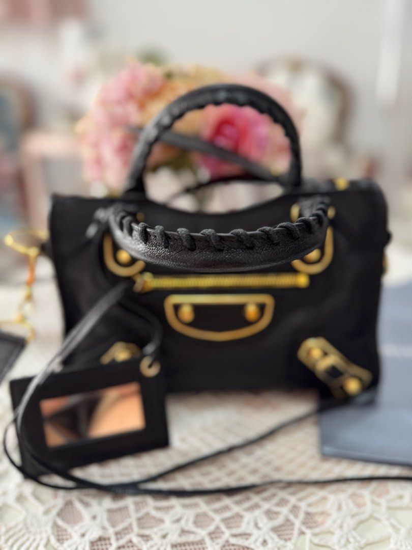 Balenciaga City Mini Bag Black (Category: Luxury Bags & Wallets) located in Marikina City. Submitted by bee031297 (Listing ID 1397091046, Image 3). Description: - Balenciaga City Mini bag - Black textured leather - Gold-tone hardware - Top handle and detachable shoulder strap - Front zip pocket - Includes mirror tag and dust bag - Zip closure - Interior condition unknown.