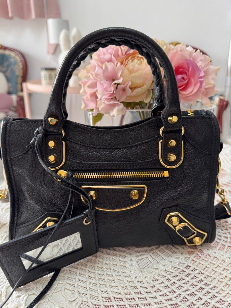 Balenciaga City Mini Bag Black (Category: Luxury Bags & Wallets) located in Marikina City. Submitted by bee031297 (Listing ID 1397091046, Image 2). Description: - Balenciaga City Mini bag - Black textured leather - Gold-tone hardware - Top handle and detachable shoulder strap - Front zip pocket - Includes mirror tag and dust bag - Zip closure - Interior condition unknown.