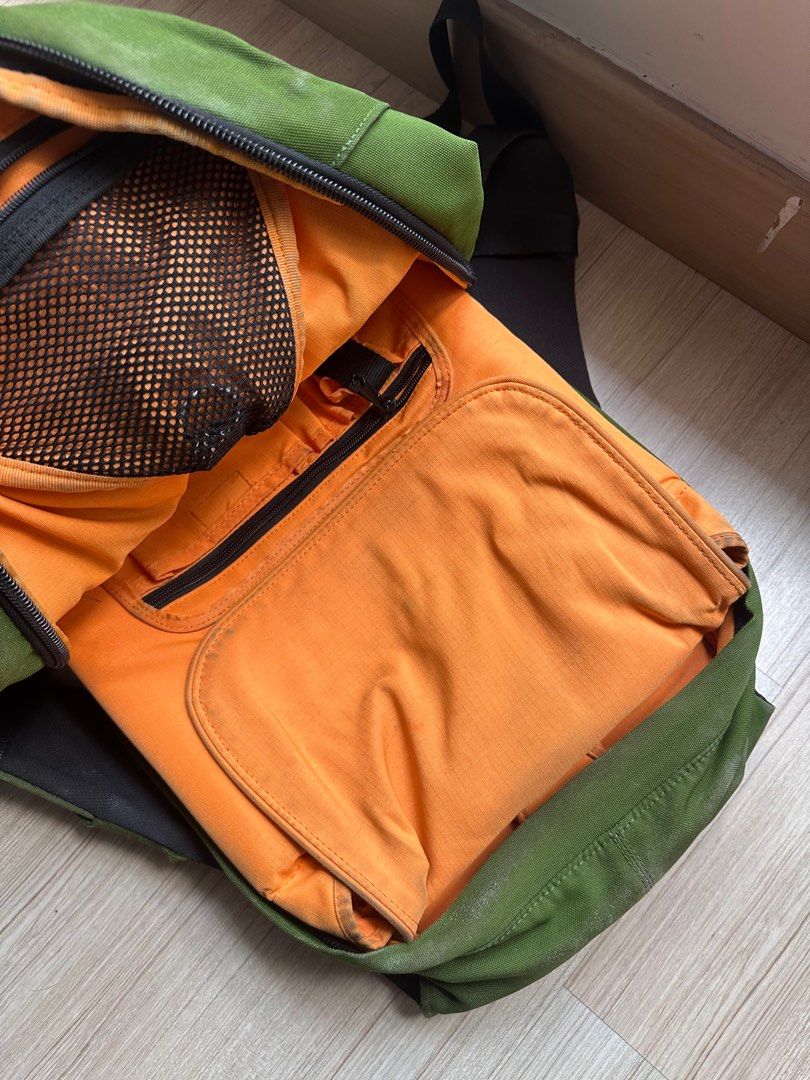 Crumpler Backpack (Category: Backpacks) located in Petaling Jaya. Submitted by fairulhilmi (Listing ID 1397192639, Image 2). Description: - Green Crumpler backpack (2007 model) - Main compartment with orange interior and mesh pocket - Padded back support - Adjustable straps - Small front zippered pocket - Unique design with central flap - Crumpler logo detailing - heavily used, now using Goruck & Evergoods for EDC - internal detachable laptop sle