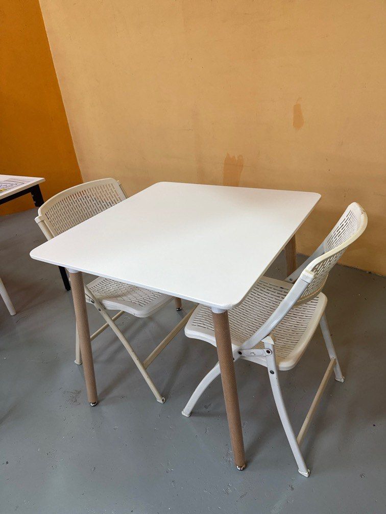 Dining Table Set (Category: Tables & Sets) located in Singapore. Submitted by edward_lcf_furniture_store (Listing ID 1397111859, Image 2). Description: Brand new 80cm square dining table White top with wooden leg comes with 2 white folding chair Diaplay set clearance One corner of table have a knock Selling this set for $90 with free delivery so no nego pls.