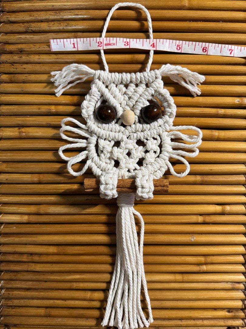 Macrame Owl Wall Hanging (Category: Wall Decor) located in Pasig City. Submitted by sinta_studio (Listing ID 1397214551, Image 1). Description: Pre-order NOW! 🫶 - Handmade macrame owl wall hanging - Beige macrame owl design - Brown/black bead eyes and wooden beak - Perched on a cinnamon stick - Long tassel at the bottom - Includes a hanging loop - Unique and charming decor Our handmade Macramé are here to add cozy charm to your home. Each knot i