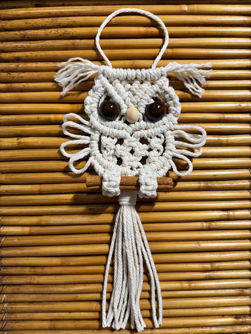 Macrame Owl Wall Hanging (Category: Wall Decor) located in Pasig City. Submitted by sinta_studio (Listing ID 1397214551, Image 2). Description: Pre-order NOW! 🫶 - Handmade macrame owl wall hanging - Beige macrame owl design - Brown/black bead eyes and wooden beak - Perched on a cinnamon stick - Long tassel at the bottom - Includes a hanging loop - Unique and charming decor Our handmade Macramé are here to add cozy charm to your home. Each knot i