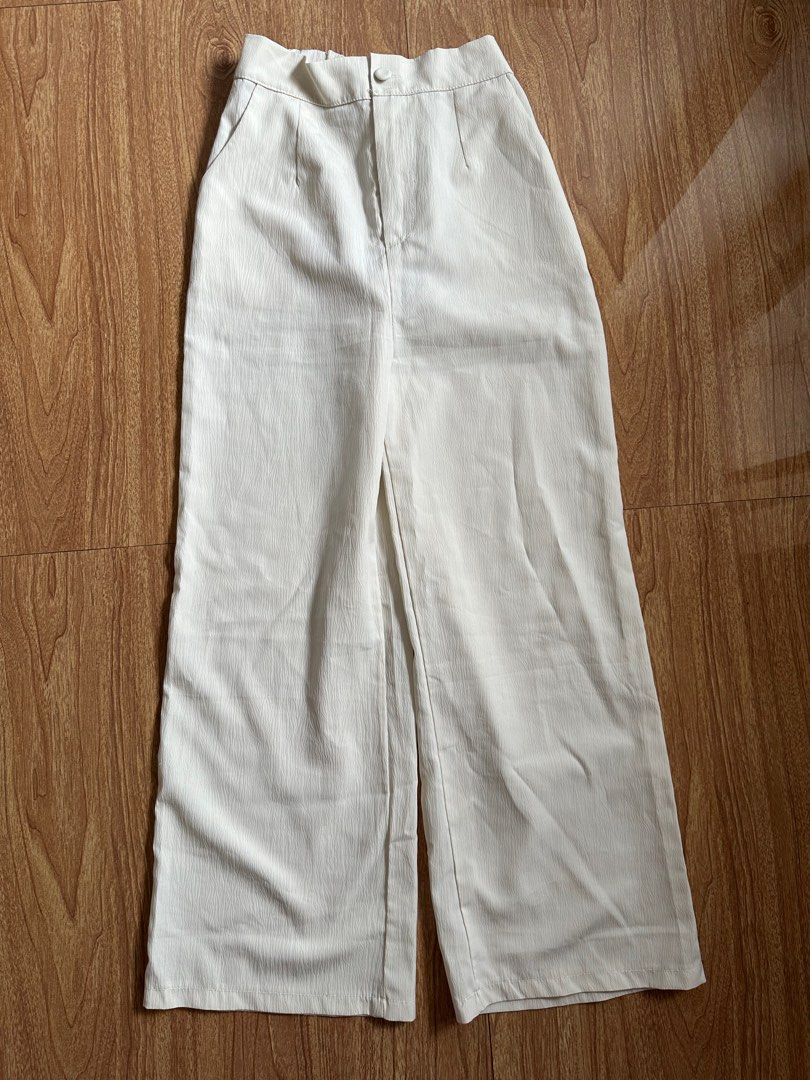 White Wide Leg Pants (Category: Other Bottoms) located in Taguig. Submitted by busybeebea (Listing ID 1397107478, Image 1). Description: - White wide-leg pants - High-waisted design - Features a button closure - Includes pockets - Made with textured fabric - Cream color for versatile styling - Visible stitching details.