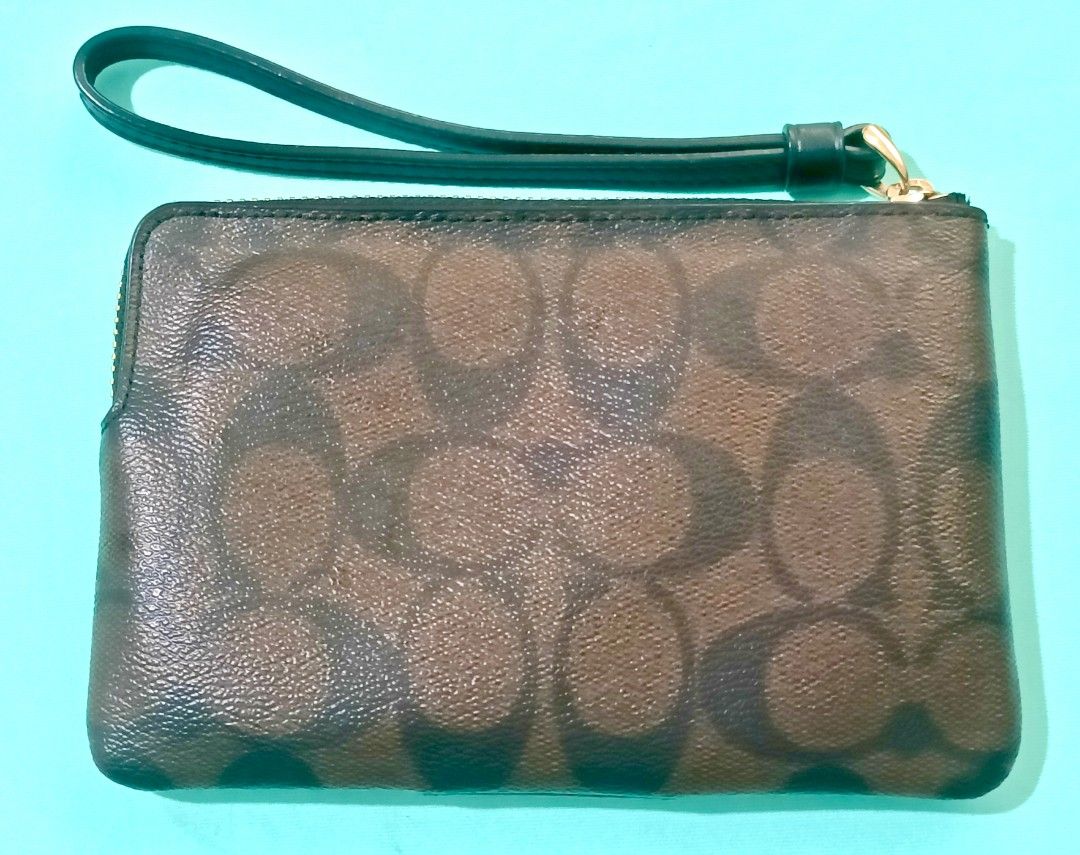 Coach Wristlet Brown Signature (Category: Luxury Bags & Wallets) located in Manila. Submitted by audrey03 (Listing ID 1397332922, Image 2). Description: - Coach wristlet - Brown signature pattern - Black leather accent - Zip closure - Wrist strap - Gold Coach logo - Stylish and practical pre -owned but never been used.