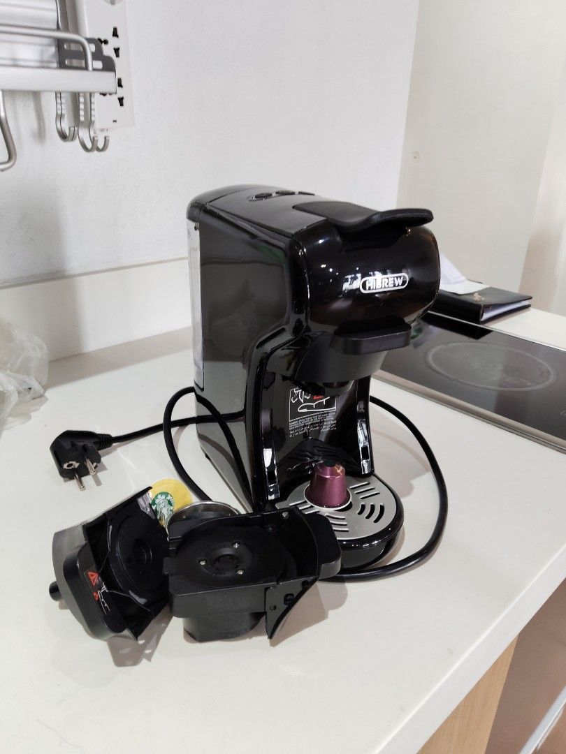 Hibrew Multi Capsule Coffee Maker ST-504 (Category: Coffee Machines & Makers) located in Makati City. Submitted by theseasonstrend (Listing ID 1397368201, Image 2). Description: Hibrew Multi Capsule Coffee Maker. Model ST-504. Includes multiple capsule adapters. Features instructions for priming the pump. The coffee maker is black. It has a power cord with a three-pin plug. The base of the machine has a label with specifications, including 1450W 
