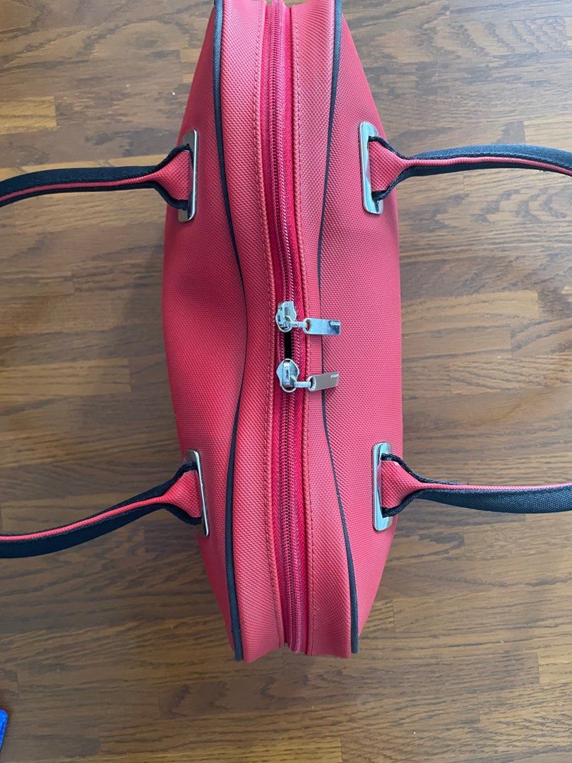 Lacoste Red Handbag (Category: Shoulder Bags) located in Quezon City. Submitted by phammy (Listing ID 1397253327, Image 3). Description: - Red Lacoste handbag - Black handles - Black trim - Double zipper closure - Small Lacoste logo - Silver-toned hardware - Textured material - minor pen mark at one side..