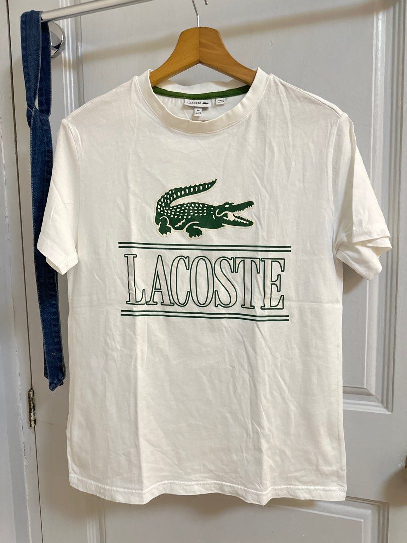 Lacoste White T-shirt Teens (Category: Tshirts & Polo Shirts ) located in Pasig City. Submitted by 4mscloset (Listing ID 1397359025, Image 1). Description: - Lacoste T-shirt - Size: 16 - Made in Tunisia - Features: Green logo and collar trim - Condition: Some stains on lower back.