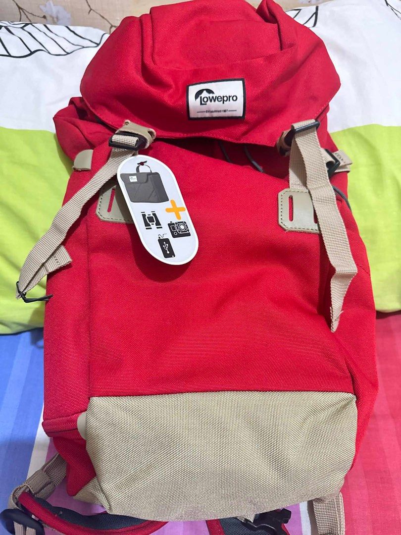 Lowepro Photo Backpack (Category: Backpacks) located in Quezon City. Submitted by marcelm.921 (Listing ID 1397282980, Image 3). Description: - Lowepro camera backpack - Color: Red and beige - Adjustable straps - Top flap closure - Padded back support for comfort - Includes tag with usage illustrations - Designed for camera equipment.