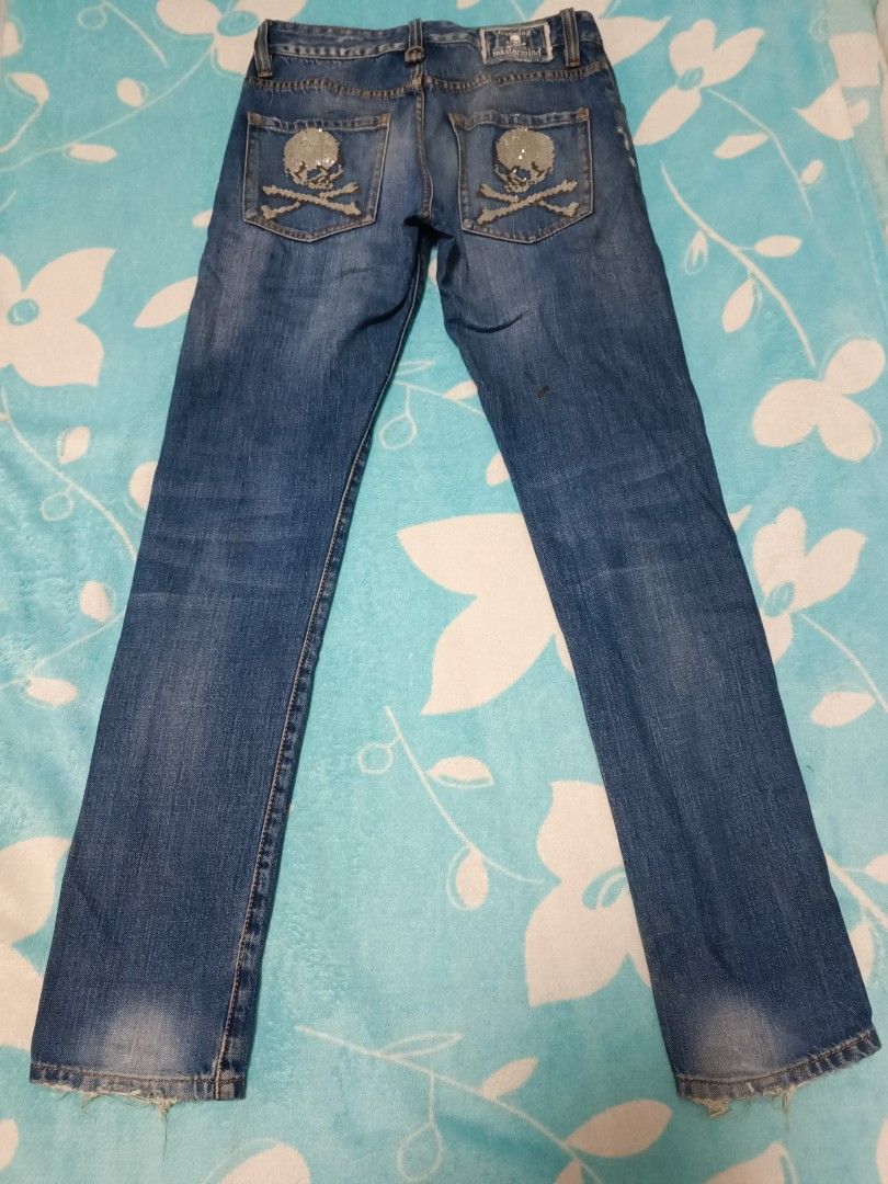 Mastermind Japan Skull Jeans (Category: Jeans) located in Quezon City. Submitted by geraldkimj97140 (Listing ID 1397359099, Image 2). Description: Stylish Mastermind Japan jeans with unique skull and crossbones detailing. Features a distressed design with patches and a size 29 waist. The jeans have a classic five-pocket design and a button closure. The back pockets are adorned with sequined skull and crossbones. The jeans also have a small skull 