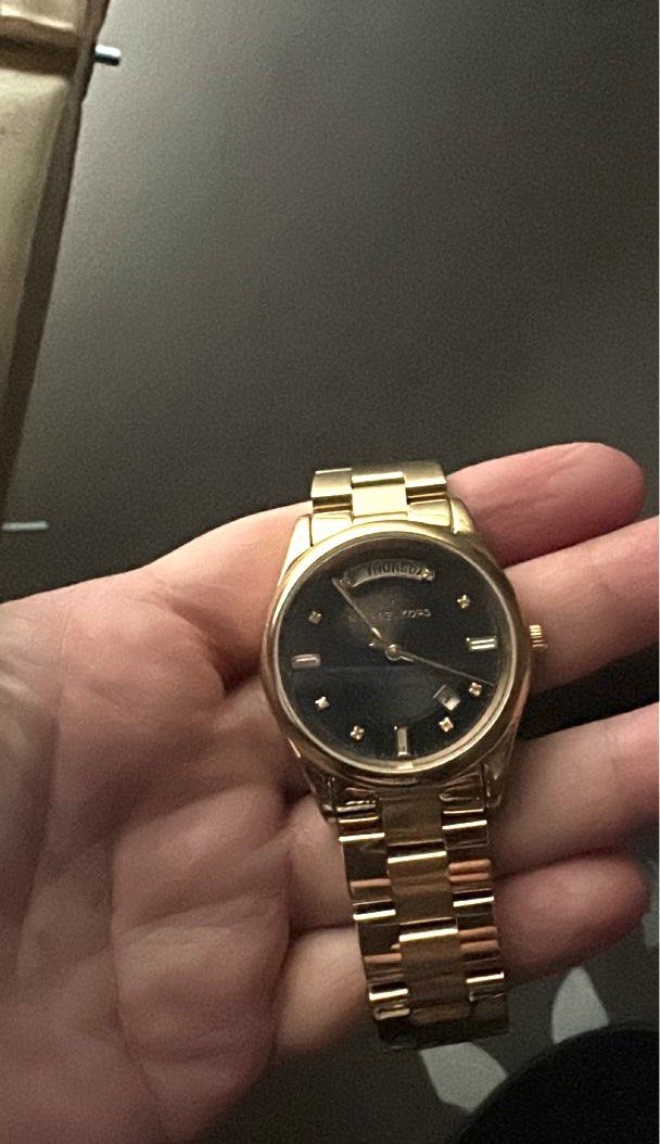 Michael Kors Gold Watch (Category: Women's Watches) located in Quezon City. Submitted by spatio (Listing ID 1397297489, Image 1). Description: - Michael Kors gold watch with extra links for strap. - no scratches; can fit a small wrist. 17 inches - Black dial - Diamond hour markers - Day-date display - Gold-tone bracelet - Secure clasp - Includes purple pouch; couldn’t find the bix anymore. - bought in MK Shangrila plaza. .