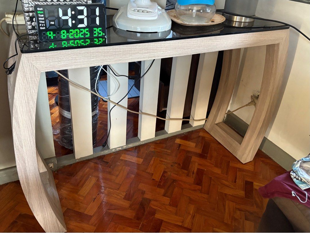 Modern Console Table with Glass Top (Category: Tables & Sets) located in Manila. Submitted by jahbey (Listing ID 1397293214, Image 1). Description: - Stylish console table - Glass top - Light wood-grain finish - Unique design - Curved legs - Sturdy construction - Suitable for entryways or living areas - Sleek and contemporary look 16inWx 42inLx 32inH.