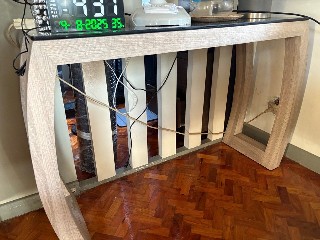 Modern Console Table with Glass Top (Category: Tables & Sets) located in Manila. Submitted by jahbey (Listing ID 1397293214, Image 2). Description: - Stylish console table - Glass top - Light wood-grain finish - Unique design - Curved legs - Sturdy construction - Suitable for entryways or living areas - Sleek and contemporary look 16inWx 42inLx 32inH.