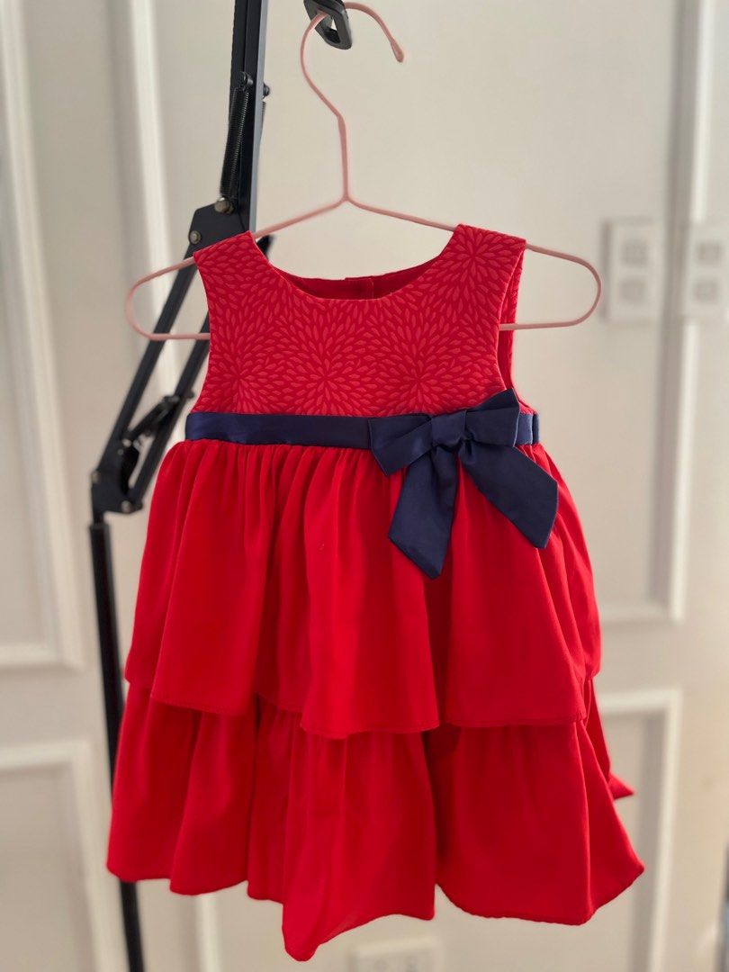 Periwinkle Red Tiered Dress with Bow (Category: Babies & Kids Fashion) located in Paranaque City. Submitted by jamrct (Listing ID 1397375571, Image 1). Description: - Adorable red dress - Tiered skirt - Navy blue bow detail - Floral patterned bodice - Navy ribbon at waist - Round neckline - Buttons at the back - Perfect for special occasions and everyday wear.