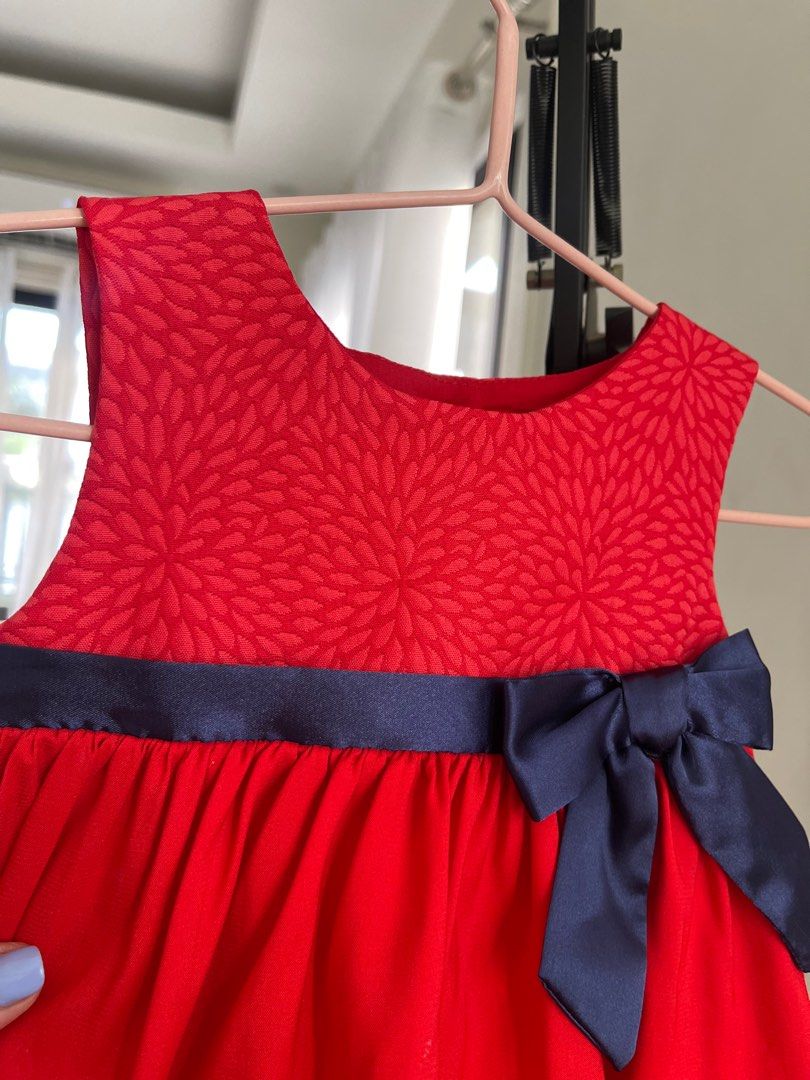Periwinkle Red Tiered Dress with Bow (Category: Babies & Kids Fashion) located in Paranaque City. Submitted by jamrct (Listing ID 1397375571, Image 2). Description: - Adorable red dress - Tiered skirt - Navy blue bow detail - Floral patterned bodice - Navy ribbon at waist - Round neckline - Buttons at the back - Perfect for special occasions and everyday wear.