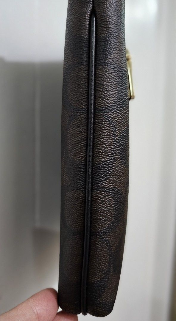 Authentic Coach Signature Mini Rowan File Bag (Category: Luxury Bags & Wallets) located in Manila. Submitted by meowlingcat (Listing ID 1401531701, Image 3). Description: - Authentic Coach crossbody bag - Signature dark brown pattern - Zip closure - Gold-tone zipper and hardware - Detachable strap - Interior pocket - Includes small tag - Compact and stylish design - Perfect for everyday use Length: 8.25" Height: 8.25" Width: 1.5".