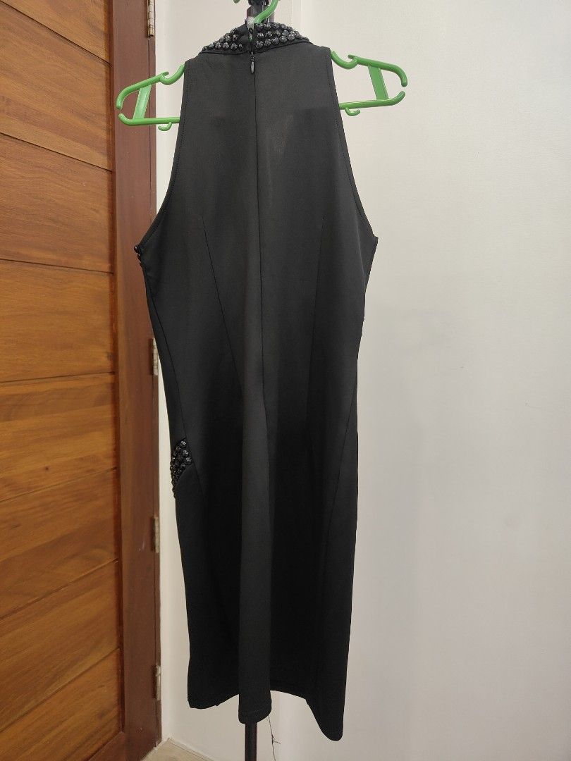 Black Embellished Halter Dress (Category: Dresses) located in Caloocan City. Submitted by cssasot (Listing ID 1401702496, Image 2). Description: Elegant black dress with embellished details. Features a halter neckline and a knee-length cut. The dress has a zipper closure at the back. Embellishments are present around the neckline and waist area. There is a small slit on the side. slight damage sa design pero pwedeng bilan ng buttons pantapal Can 