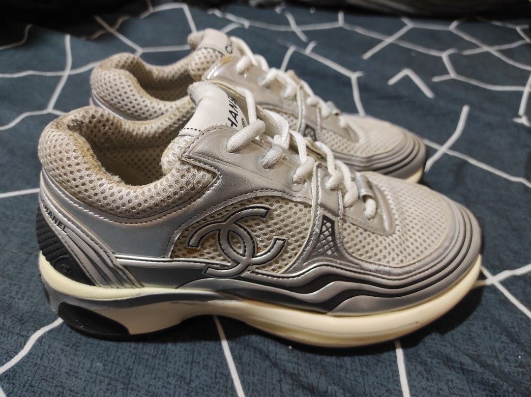 Chanel metallic trainers (Category: Sneakers & Footwear) located in Manila. Submitted by luxxxxxxxx.x (Listing ID 1401647136, Image 1). Description: Chanel sneakers. Features a mesh upper with silver accents and the iconic Chanel logo. The sneakers are size 36 and made in Italy. The soles show some wear. The shoes have white laces and a cushioned sole for comfort. The Chanel logo is visible on the tongue and the sole..
