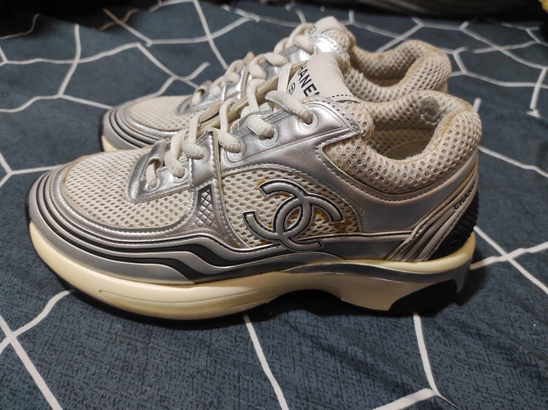 Chanel metallic trainers (Category: Sneakers & Footwear) located in Manila. Submitted by luxxxxxxxx.x (Listing ID 1401647136, Image 3). Description: Chanel sneakers. Features a mesh upper with silver accents and the iconic Chanel logo. The sneakers are size 36 and made in Italy. The soles show some wear. The shoes have white laces and a cushioned sole for comfort. The Chanel logo is visible on the tongue and the sole..