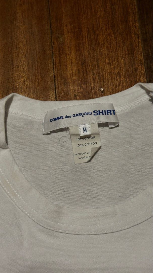 Comme des Garcons Shirt x KAWS Graphic Tee (Category: Luxury Apparel) located in Quezon City. Submitted by area008 (Listing ID 1401655588, Image 3). Description: Kaws x Comme des Garçons white graphic shirt AUTHENTIC CONDITION 9.5/10 May stain sa left top shoulder pero not permanent damage.