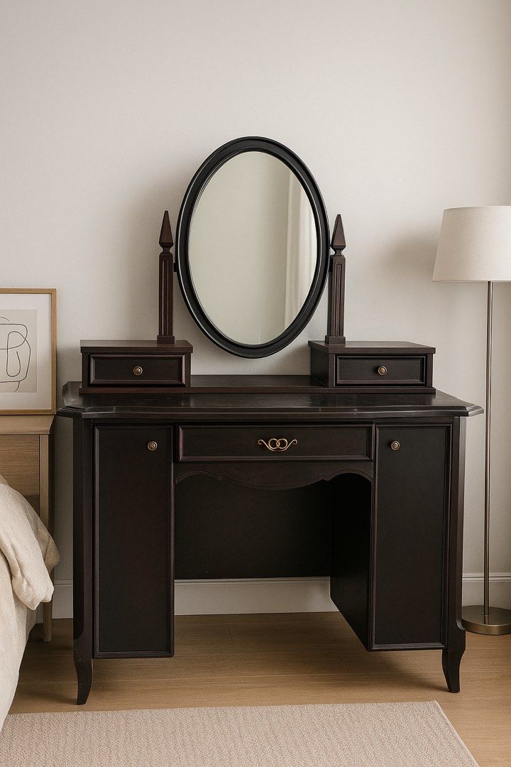 Dark Wood Vanity Table with Oval Mirror (Category: Tables & Sets) located in Angeles City. Submitted by maryannmar33098 (Listing ID 1401712430, Image 1). Description: - Dark wood vanity table - Oval mirror - Two small side drawers - Central drawer with gold handle - Two cabinet doors - Curved legs - Classic design - Ideal for bedroom or dressing area.