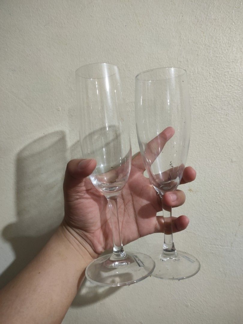 Set of 2 Champagne Flutes (Category: Dinnerware & Cutlery) located in Binan City. Submitted by ajsdcruz (Listing ID 1401547997, Image 1). Description: Elegant set of two champagne flutes. These glasses have a classic, tall design with a slender stem and a wide base for stability. They are made of clear glass, perfect for showcasing the bubbles of your favorite champagne or sparkling wine. Ideal for special occasions or adding a touch of sophistic