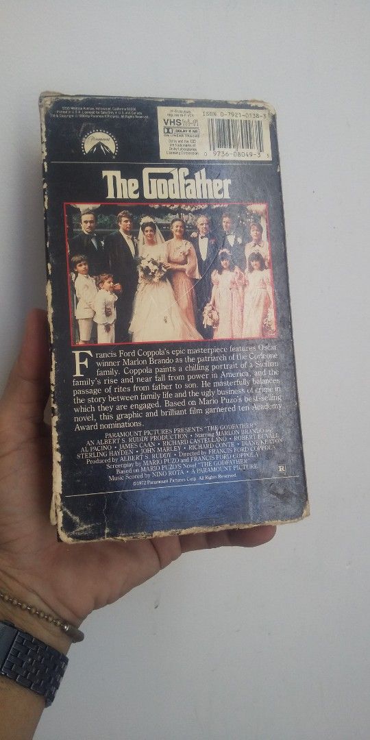 The Godfather VHS Tape (Category: Storybooks) located in Carmona. Submitted by rpute (Listing ID 1401606246, Image 2). Description: Godfather VHS tape. Features the movie title on the front and back of the case. The back of the case shows a wedding scene. The tape is labeled as -Fi. Produced by Paramount..