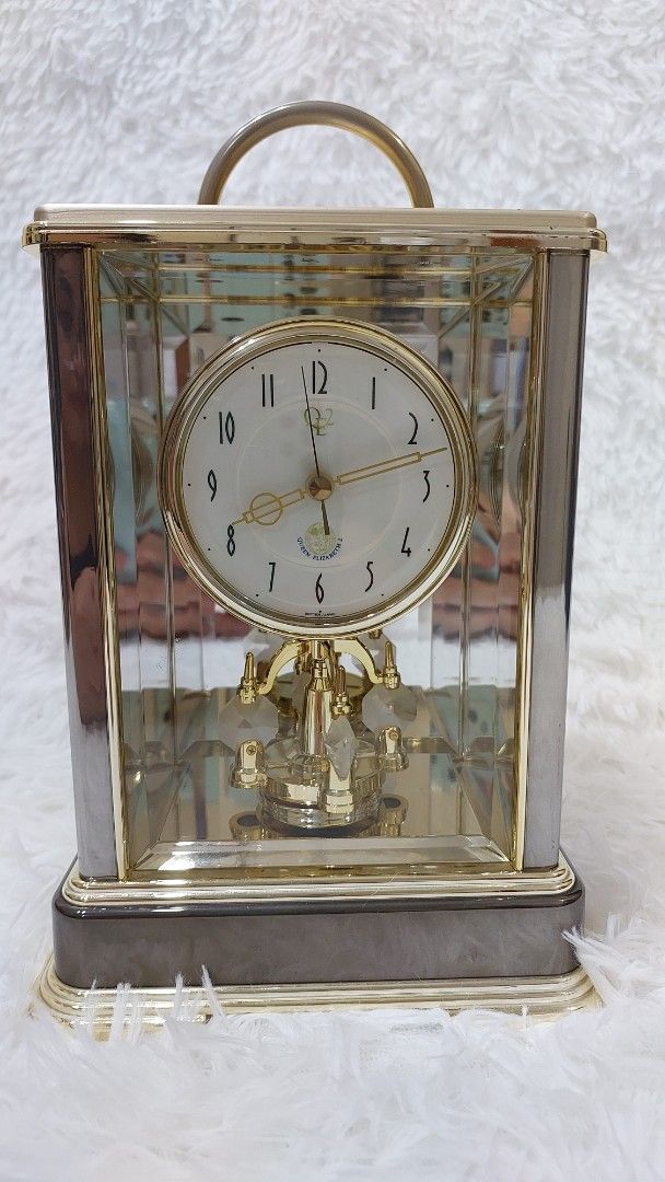 Vintage Gold and Glass Clock (Category: Clocks) located in Binan City. Submitted by sakuratreasuresph (Listing ID 1401638885, Image 2). Description: Vintage Queen Elizabeth II Commemorative Mantel Clock A finely crafted crystal mantel clock featuring a mirrored glass case, gold-tone frame, and rotating pendulum. A timeless piece of elegance, perfect for discerning collectors and those who appreciate refined home decor. 📏 Approx. Measurements: H 