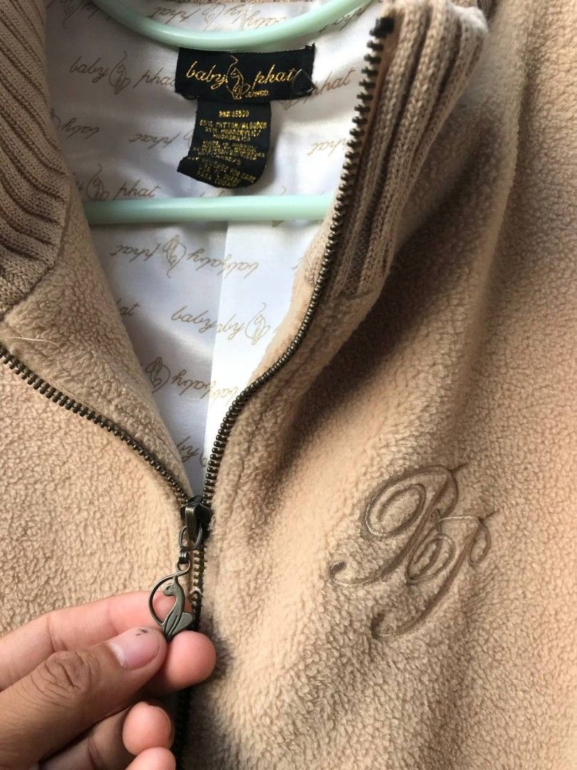 Baby Phat Fleece Jacket (Category: Coats, Jackets and Outerwear) located in Cotabato. Submitted by deneiljohn (Listing ID 1403348611, Image 2). Description: - Baby Phat fleece jacket - Neutral beige color - Size Large - Full zip closure - Two front pockets - Ribbed collar and cuffs - Embroidered Baby Phat logo on chest - Metal logo tag at hem - Lined with Baby Phat logo print.