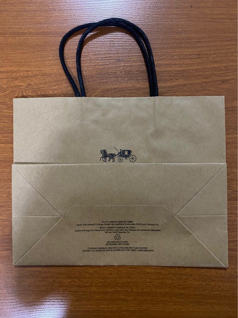 Coach Gift Bag (Category: Luxury Bags & Wallets) located in Quezon City. Submitted by harleys_stuff (Listing ID 1403366147, Image 2). Description: Authentic Coach paper bag. Features the Coach logo and a horse-drawn carriage graphic. Made of brown paper with black handles. Dimensions are approximately 22.5 cm in height and 28 cm in length. Includes the Coach New York logo. Made in China..