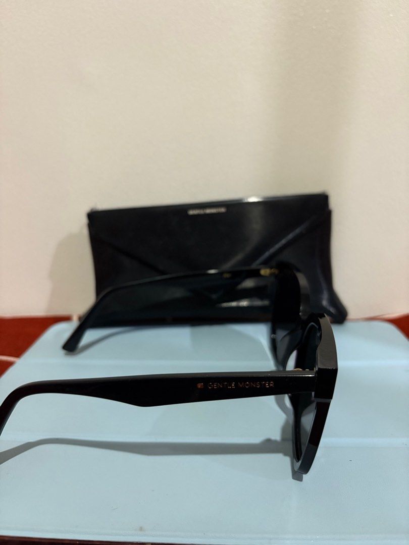 Gentle Monster HER 01 SUNGLASSES (Category: Sunglasses & Eyewear) located in Mandaluyong City. Submitted by bluezzzzz (Listing ID 1403341515, Image 3). Description: AE - Authentic Gentle Monster HER 01 sunglasses - Black frame with dark lenses - Includes box and cleaning cloth - Features a stylish, oversized design - Gentle Monster logo visible on case and paperwork - Perfect accessory.