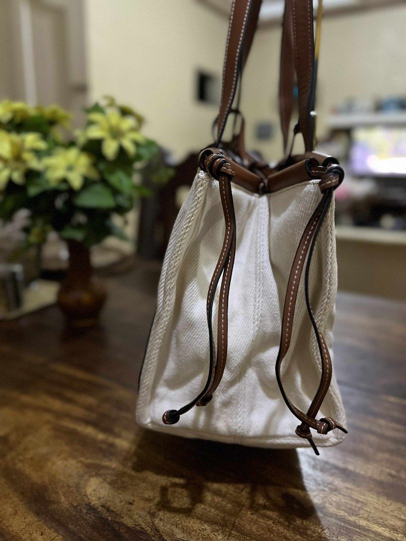 Loewe Canvas Tote Bag (Category: Luxury Bags & Wallets) located in Bacolod City. Submitted by novymaesel14868 (Listing ID 1403367815, Image 2). Description: - Authentic Loewe tote bag. - Durable canvas body. - Elegant brown leather trim and handles. - Iconic Loewe logo patch. - Stylish rectangular shape. - Unique drawstring details on the sides. - Interior condition unknown..