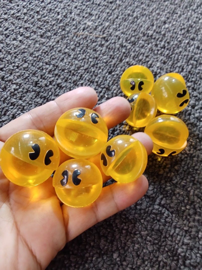 Pacman Toy Balls (Category: Kids Toys) located in Bocaue. Submitted by marajapansurplus (Listing ID 1403271754, Image 3). Description: - Set of Pacman-themed toy balls - Yellow balls with black Pacman faces - Some balls are split in half - Small, plastic construction - Ideal for collectors or as a fun toy.
