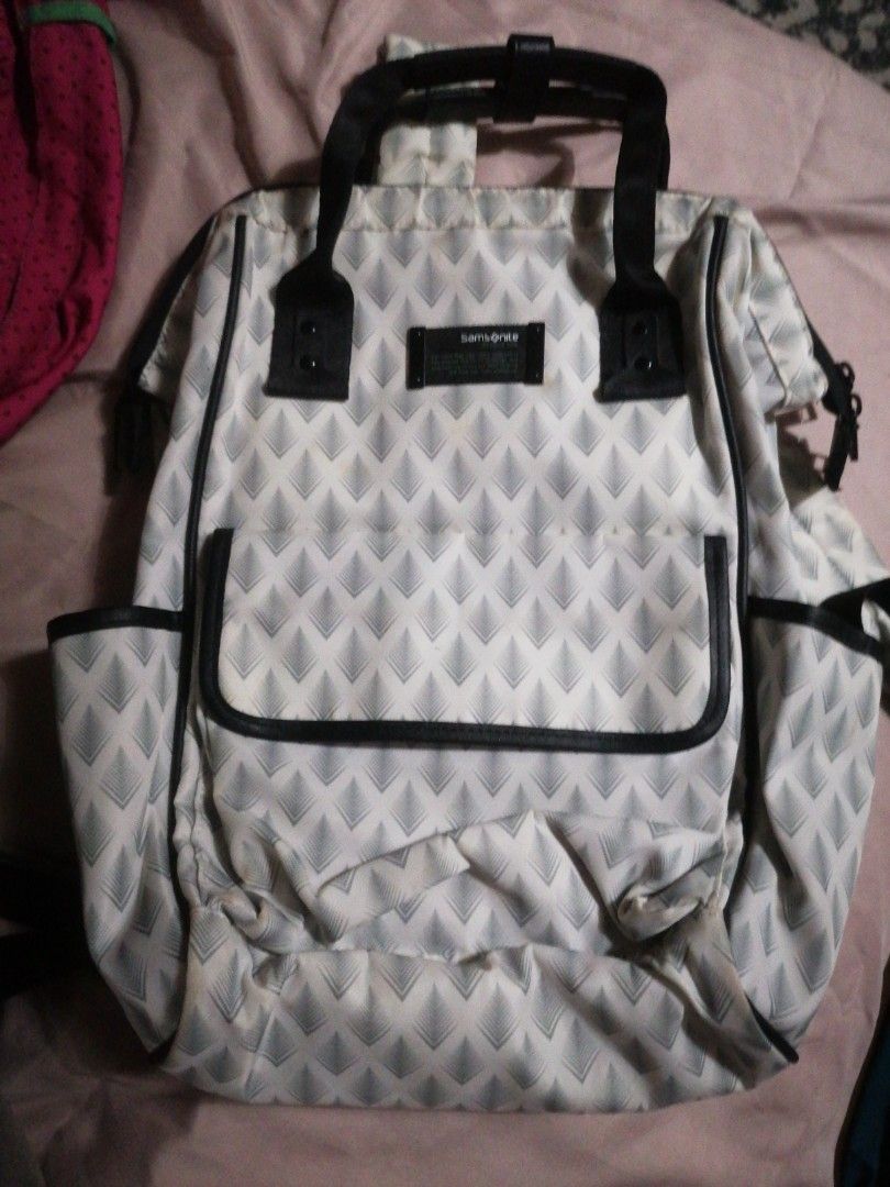 Samsonite Backpack (Category: Backpacks) located in Makati City. Submitted by divimall9928169 (Listing ID 1403273162, Image 2). Description: - Samsonite backpack with a unique geometric pattern. - Spacious main compartment with red lining. - Multiple pockets for organization. - Includes front and side pockets. - Black handle and straps. - Black mesh back pocket..